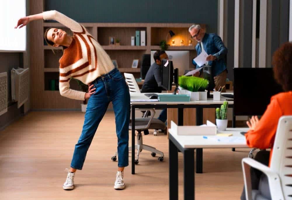 Mulher aproveitando o tema que sobra no trabalho para alongar, porque ela usa Inteligência Artifical para poder agilizar tarefas repetitivas no trabalho.