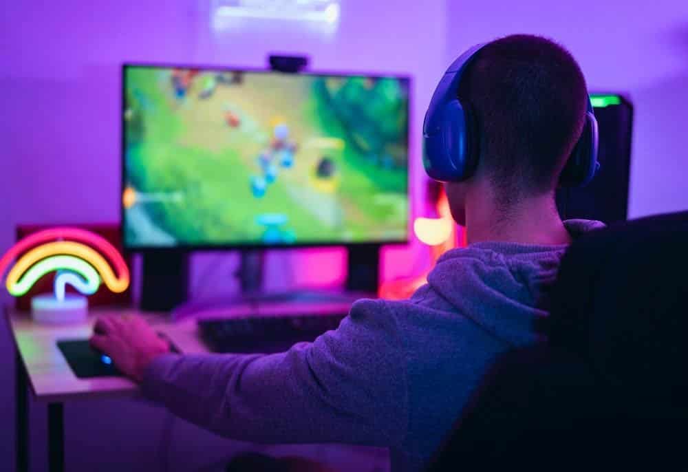 Imagem de um gamer com fones de ouvido jogando, representando o lançamento de uma estratégia de marketing digital por uma agência de marketing. Os jogos mais esperados de 2025