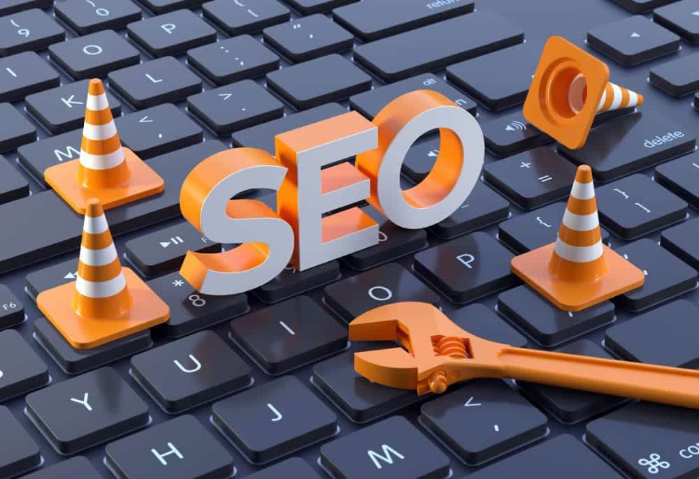 SEO representado com cones de tráfego e chave inglesa sobre teclado, simbolizando lançamento e otimização por agência de marketing digital.